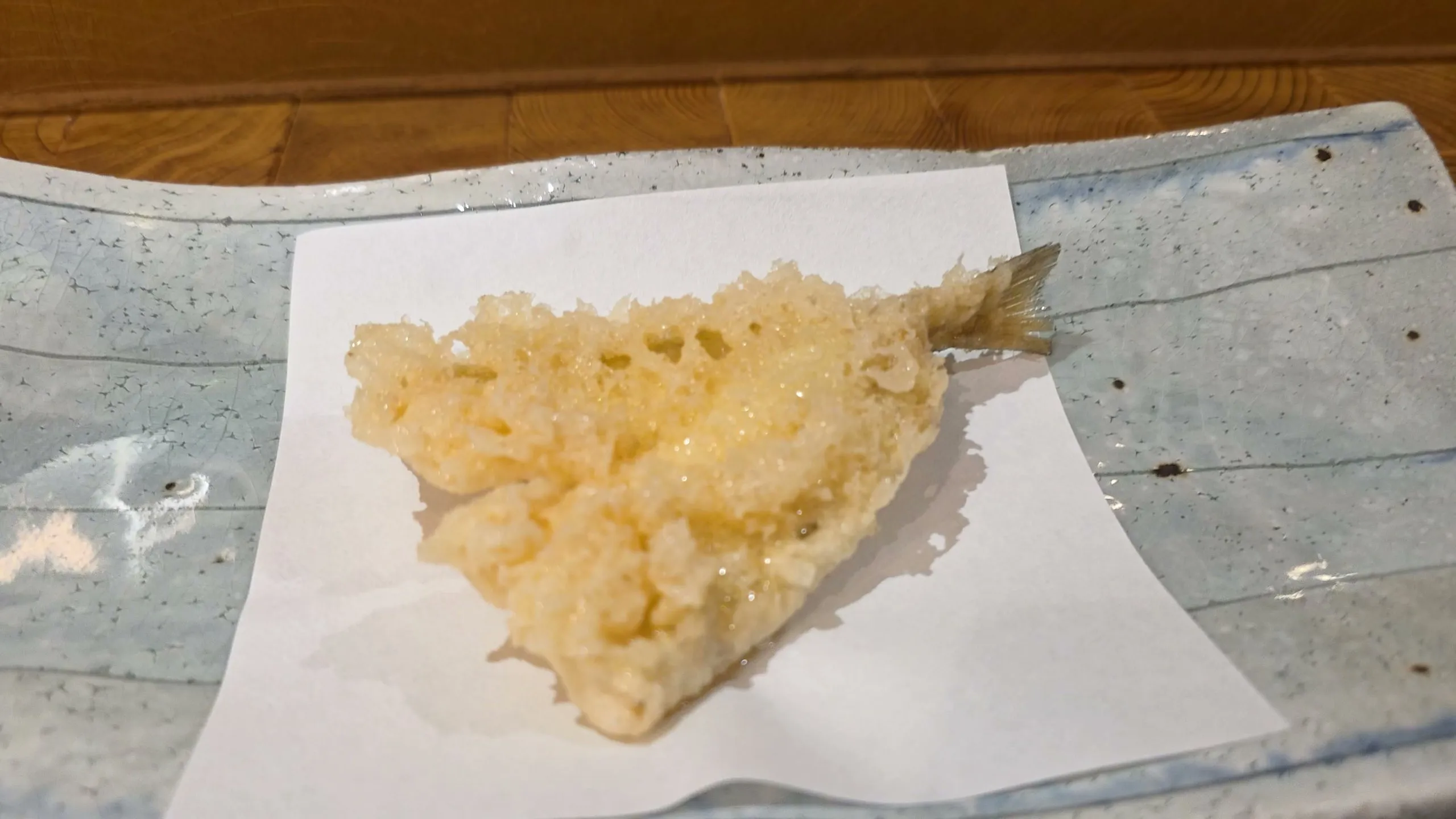 Kisu (Japanese whiting) tempura with its tail on white paper
