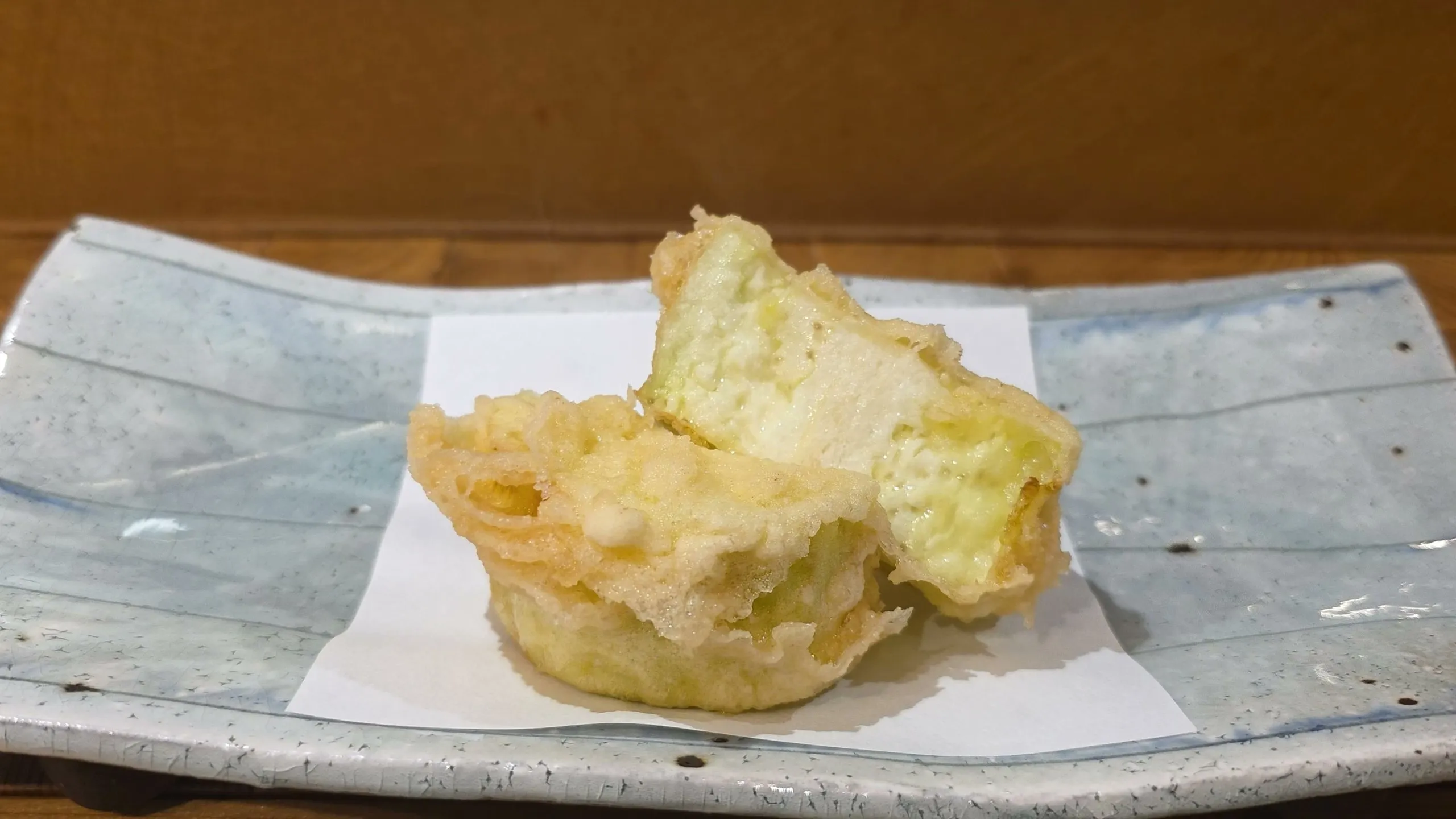 Eggplant tempura cut open to show the pale, soft flesh