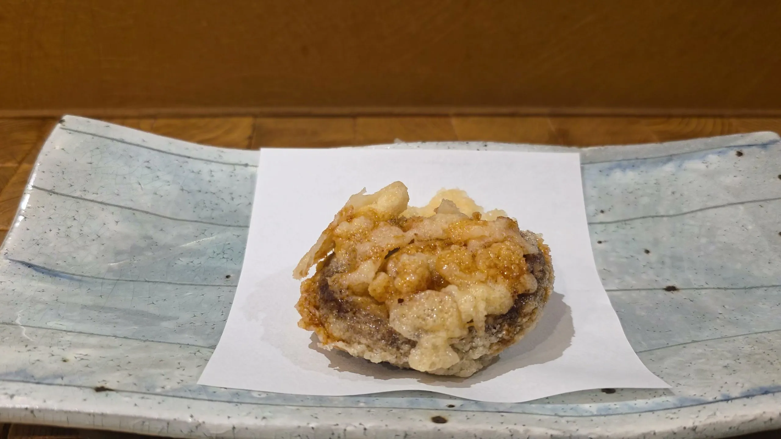 Shiitake tempura glazed with sauce on white paper