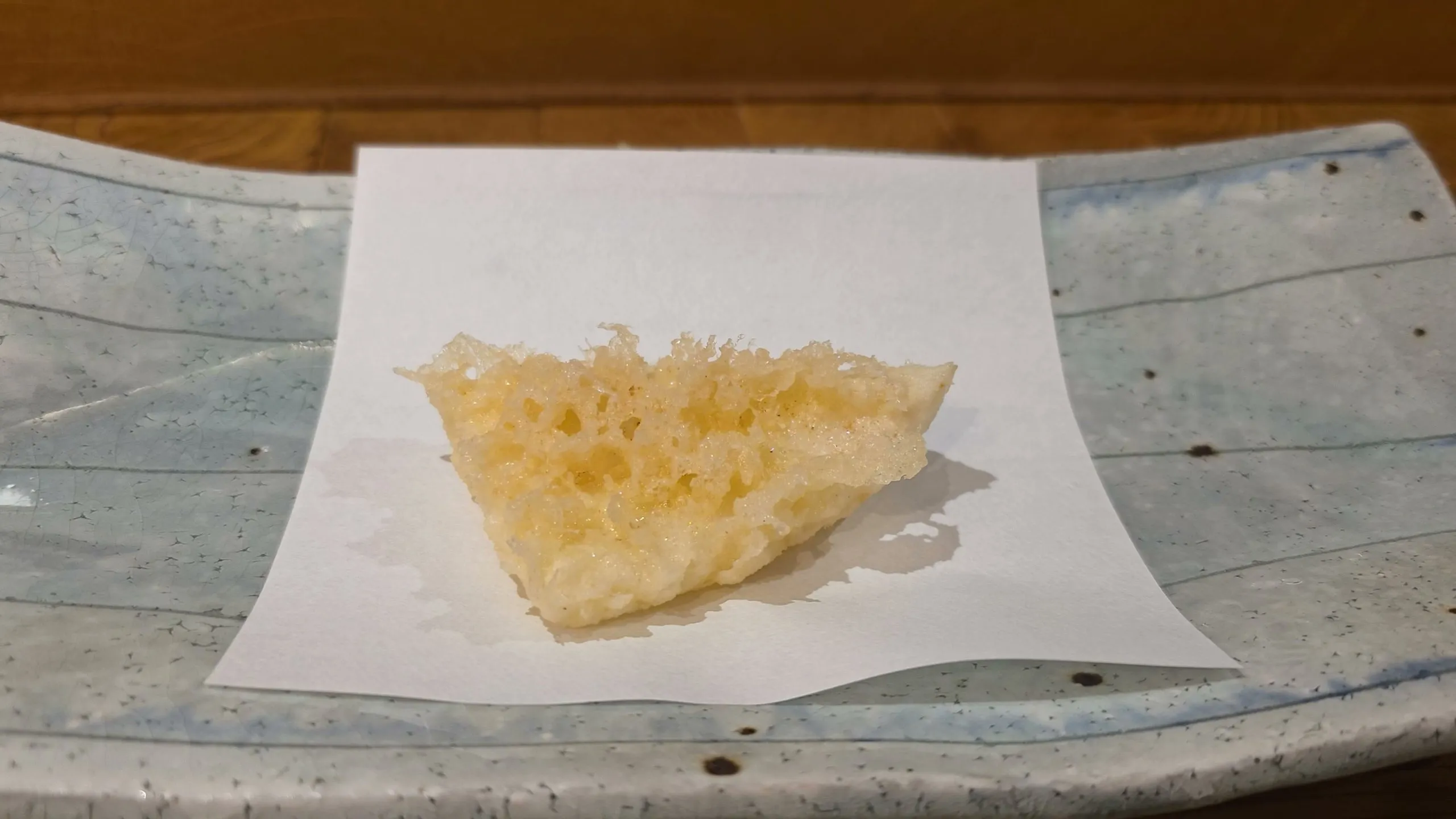 Shin-ika baby cuttlefish tempura with lacy batter on white paper